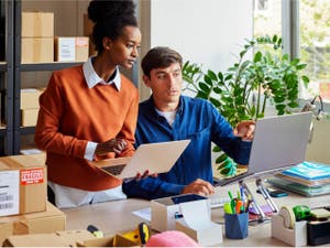 Coworkers on laptops in an office resolving and managing a customer dispute