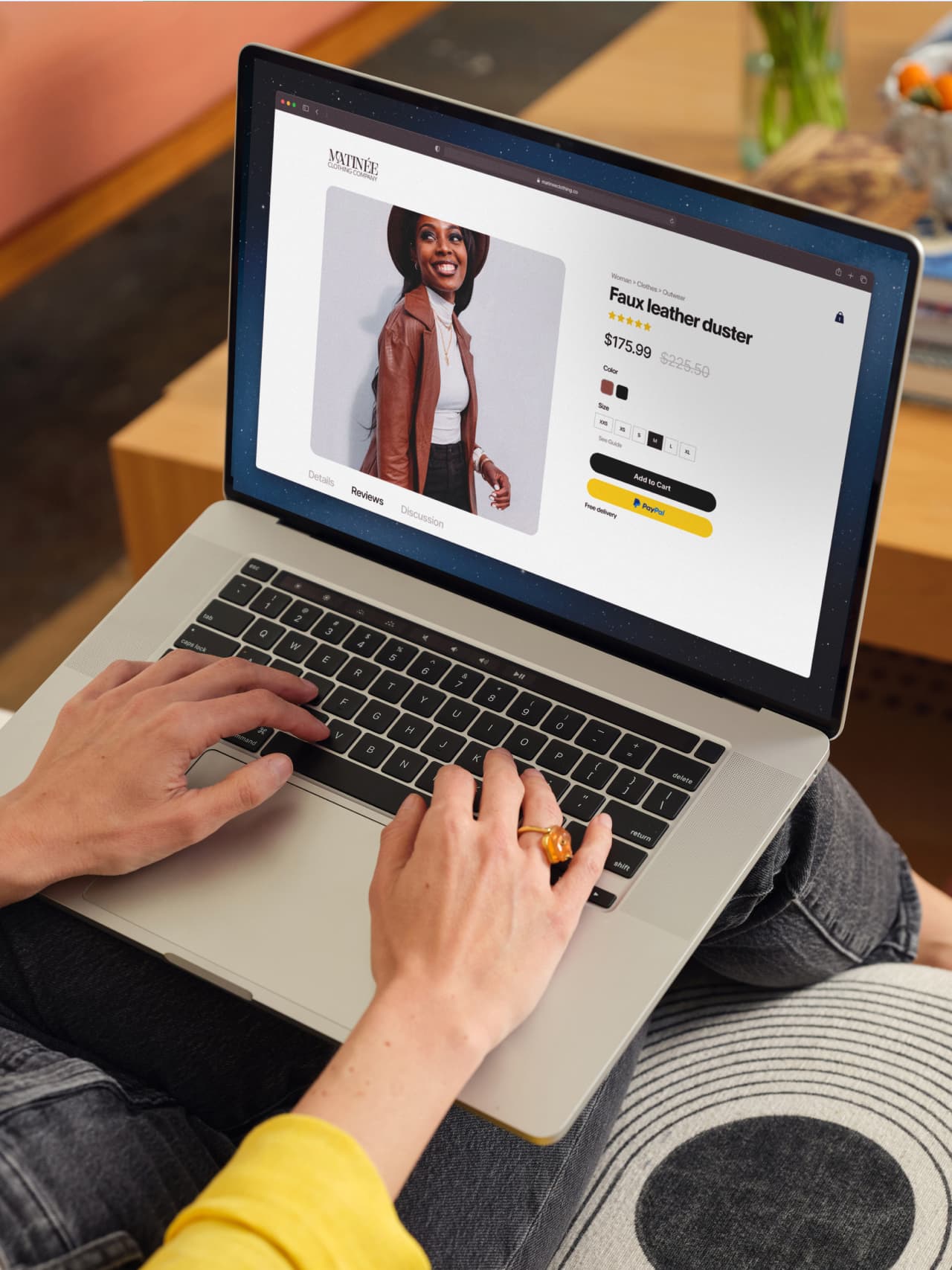 Woman holding a laptop on her lap shopping online