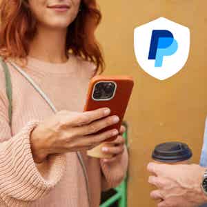 Person holding coffee cup and using phone with red case